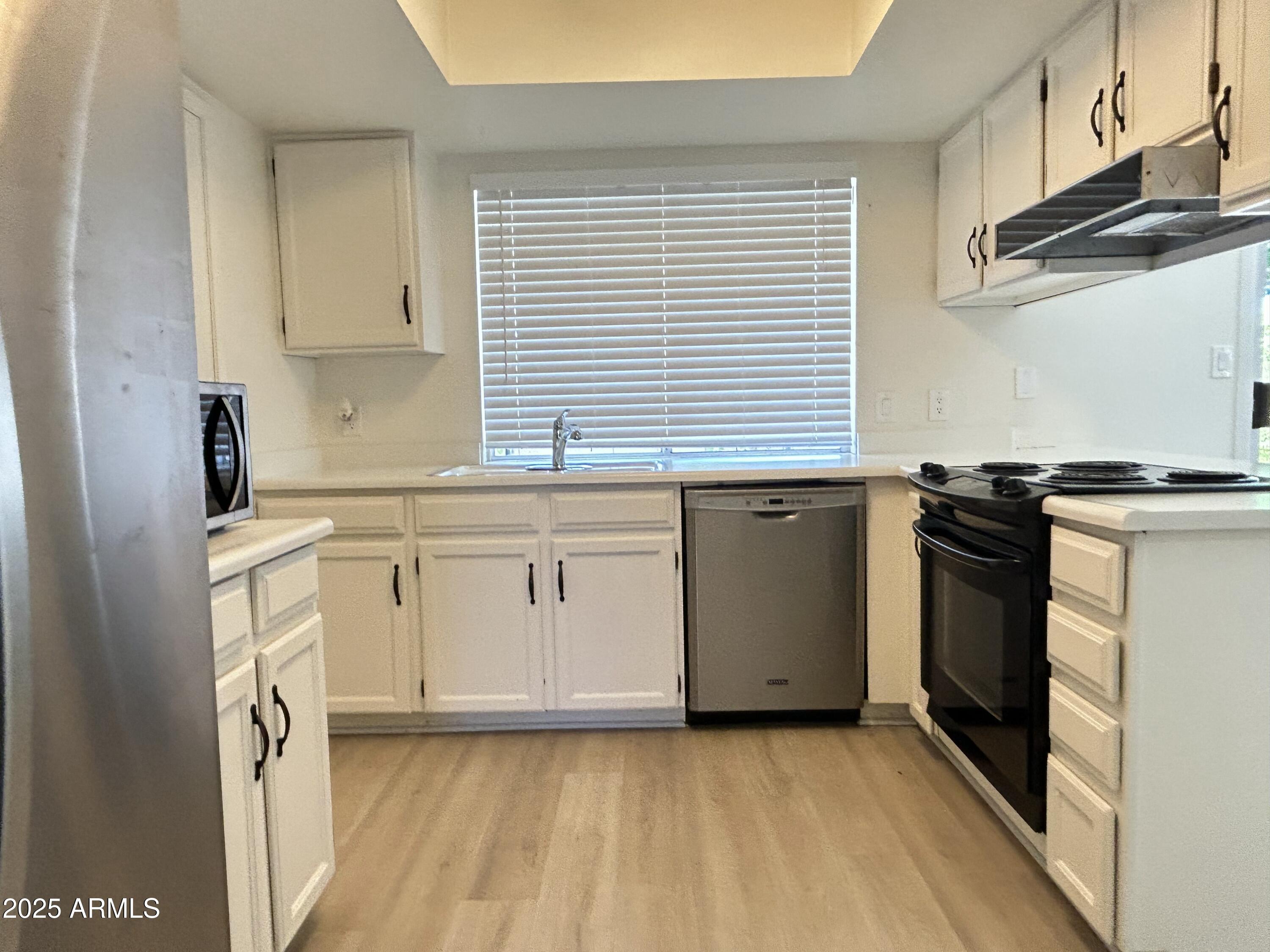 17838 North 45th Avenue Glendale, AZ 85308 - Photo 6 of 17 a kitchen with stainless steel appliances a stove a sink and a refrigerator