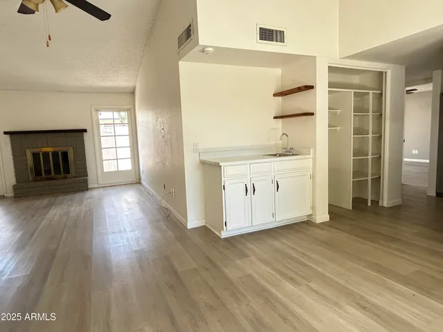a view of a kitchen with wooden floor and a ceiling fan