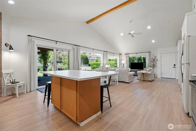 a view of kitchen with stainless steel appliances granite countertop sink stove and wooden floor