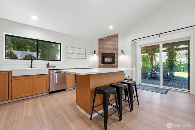 a kitchen with stainless steel appliances granite countertop wooden floor a sink a stove and a refrigerator