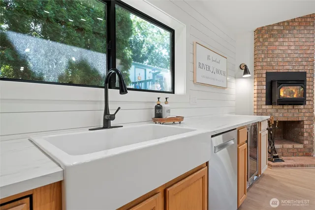 a kitchen with a sink a counter top space and a fireplace