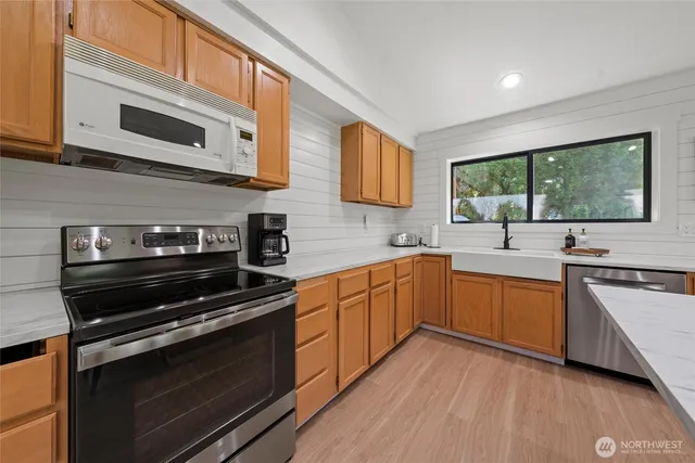 a kitchen with stainless steel appliances a stove sink and cabinets