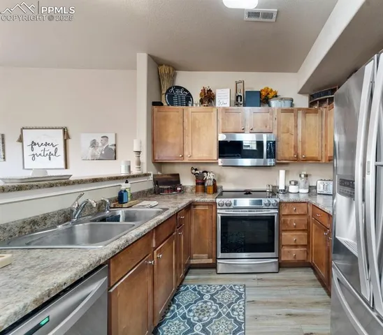 a kitchen with stainless steel appliances granite countertop a sink stove and refrigerator