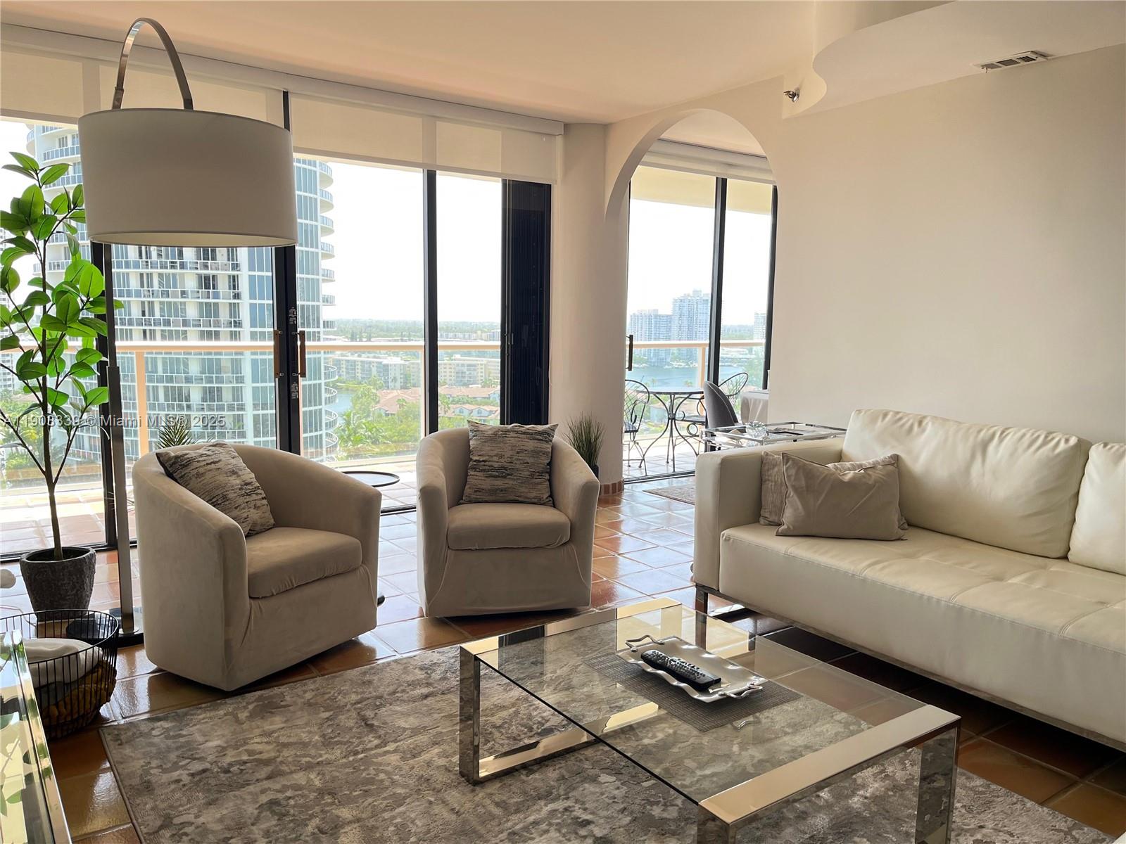 4000 Island Boulevard, Unit 1703 Aventura, FL 33160 - Photo 11 of 29 a living room with furniture and a large window