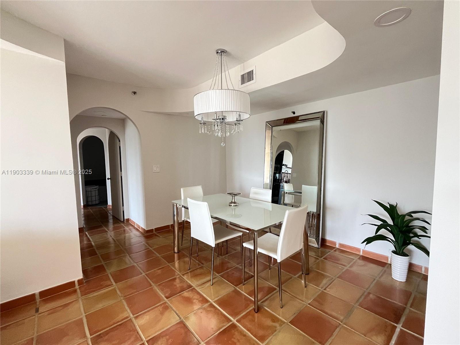 4000 Island Boulevard, Unit 1703 Aventura, FL 33160 - Photo 12 of 29 a view of a dining room with furniture and chandelier