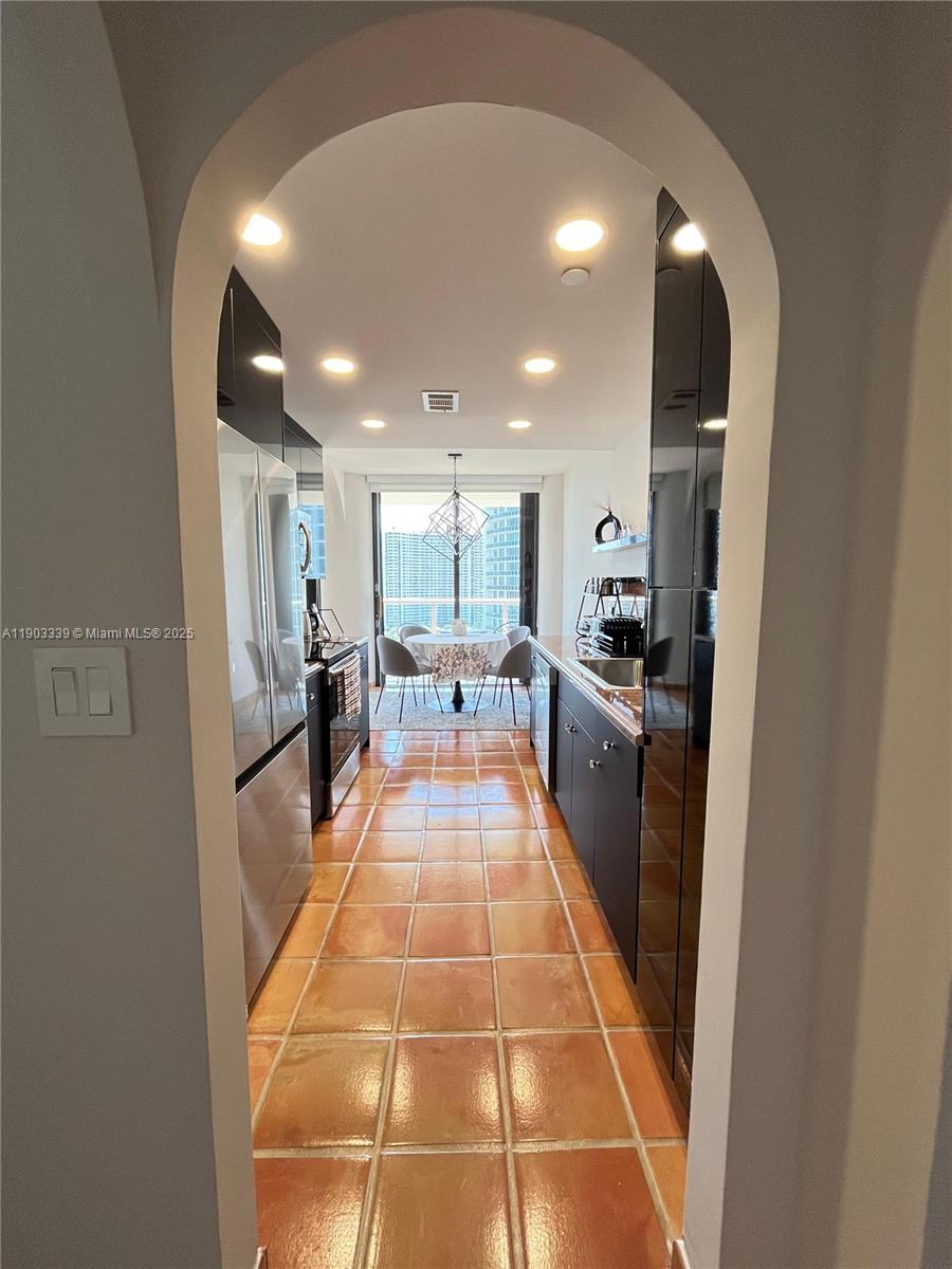 4000 Island Boulevard, Unit 1703 Aventura, FL 33160 - Photo 13 of 29 a large white kitchen with stainless steel appliances granite countertop a refrigerator and a sink