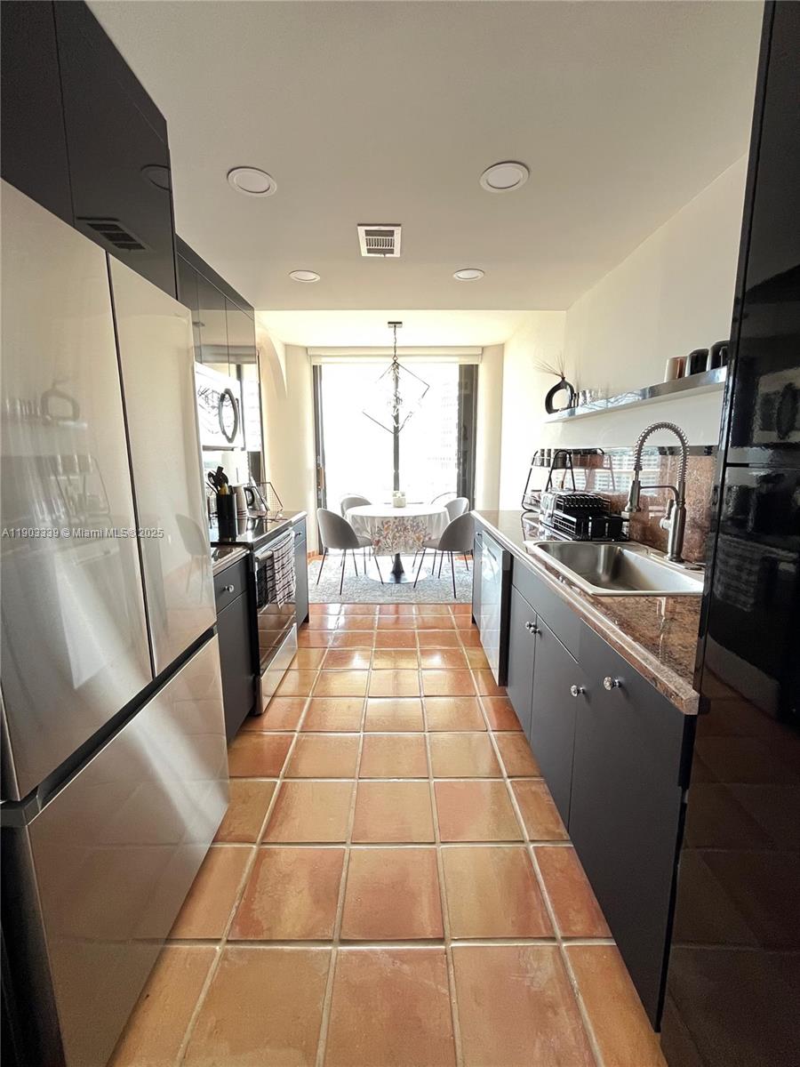 4000 Island Boulevard, Unit 1703 Aventura, FL 33160 - Photo 14 of 29 a kitchen with stainless steel appliances granite countertop a refrigerator and a stove top oven