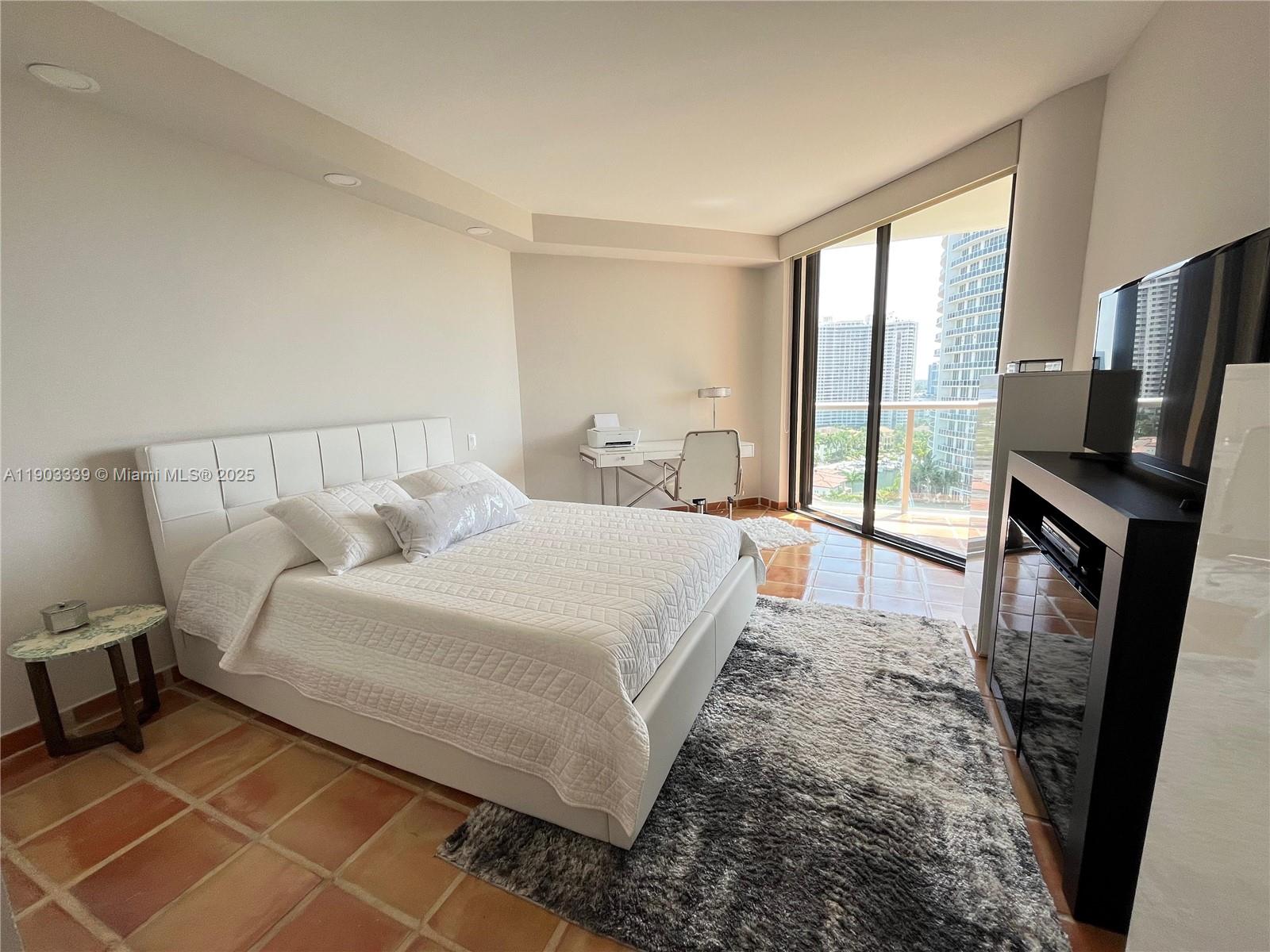 4000 Island Boulevard, Unit 1703 Aventura, FL 33160 - Photo 18 of 29 a bed room with a bed and a television