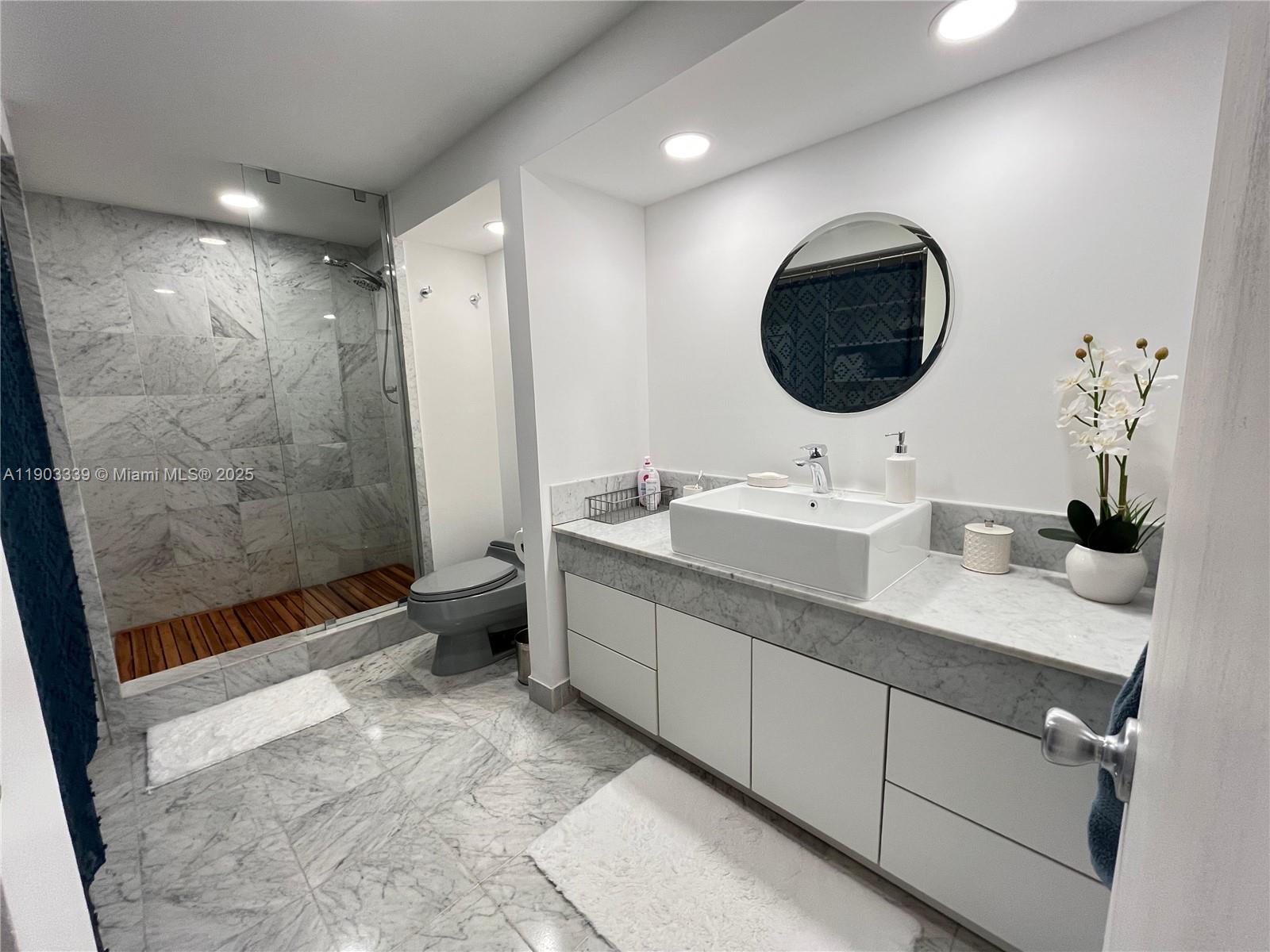 4000 Island Boulevard, Unit 1703 Aventura, FL 33160 - Photo 20 of 29 a bathroom with a double vanity sink toilet and shower