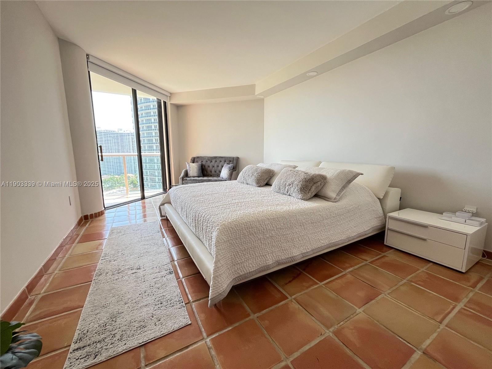 4000 Island Boulevard, Unit 1703 Aventura, FL 33160 - Photo 25 of 29 a large bedroom with a bed and large window