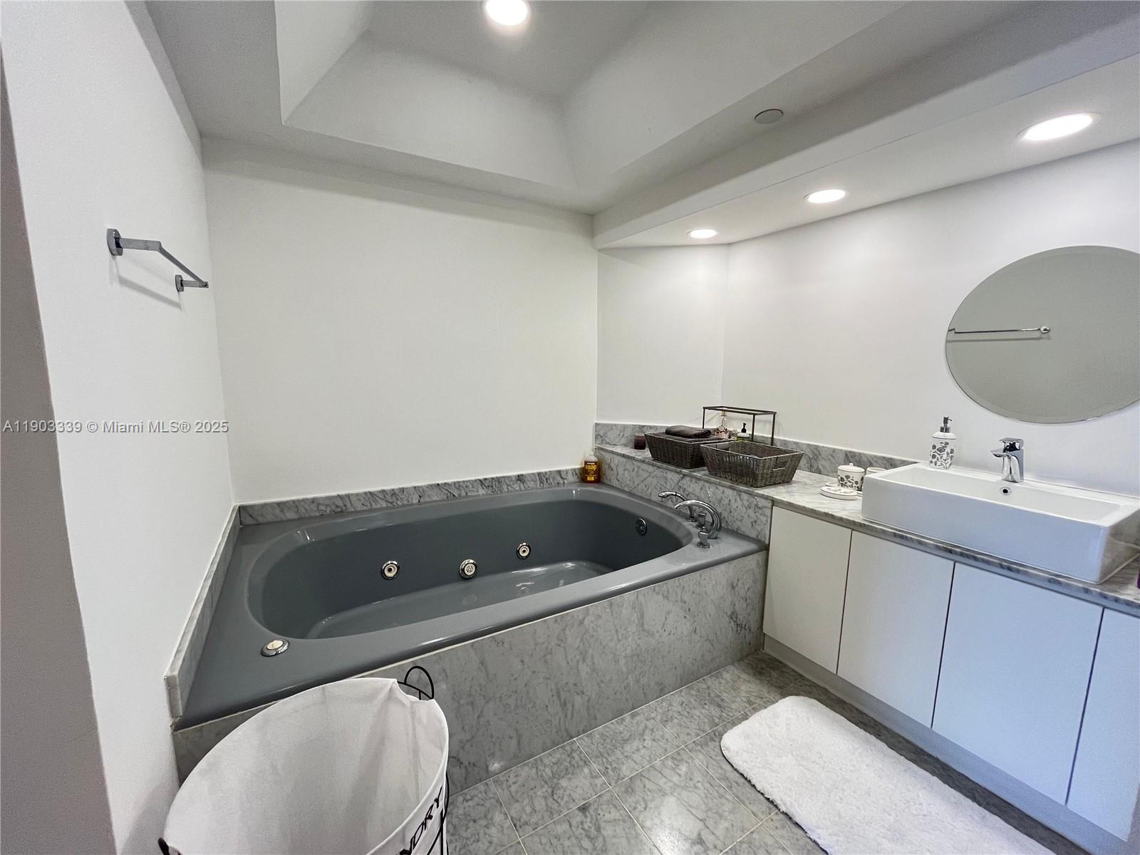 4000 Island Boulevard, Unit 1703 Aventura, FL 33160 - Photo 27 of 29 a bathroom with a sink a toilet and a mirror