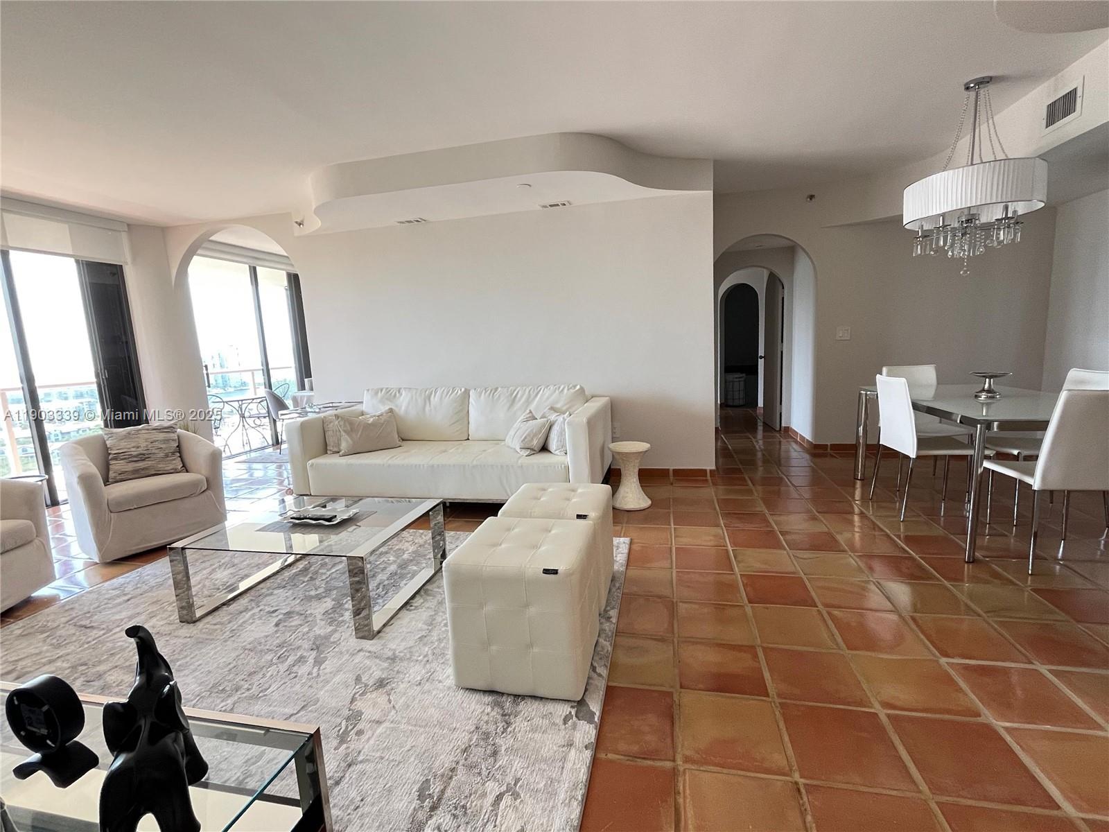 4000 Island Boulevard, Unit 1703 Aventura, FL 33160 - Photo 8 of 29 a living room with patio furniture and a dining table