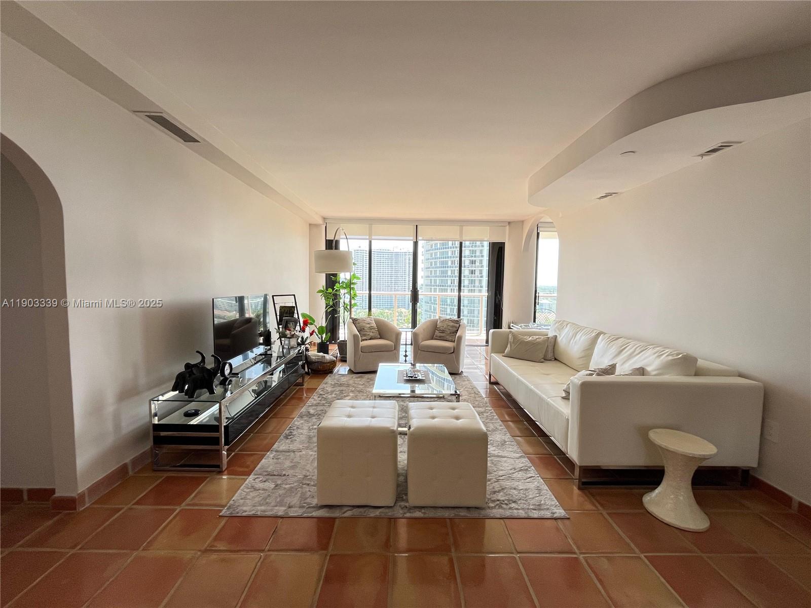 4000 Island Boulevard, Unit 1703 Aventura, FL 33160 - Photo 10 of 29 a living room with furniture and a large window