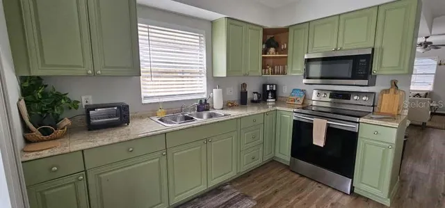 a kitchen with stainless steel appliances granite countertop a sink stove and microwave