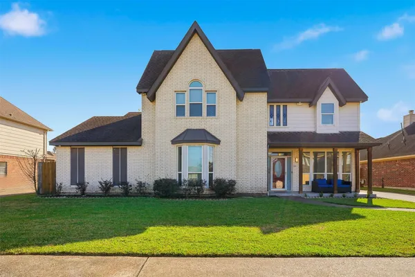 a front view of a house with a yard and trees