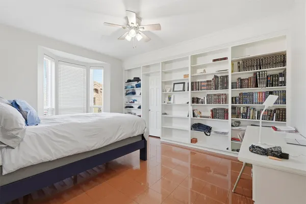 a bedroom with a bed a table and bookshelf