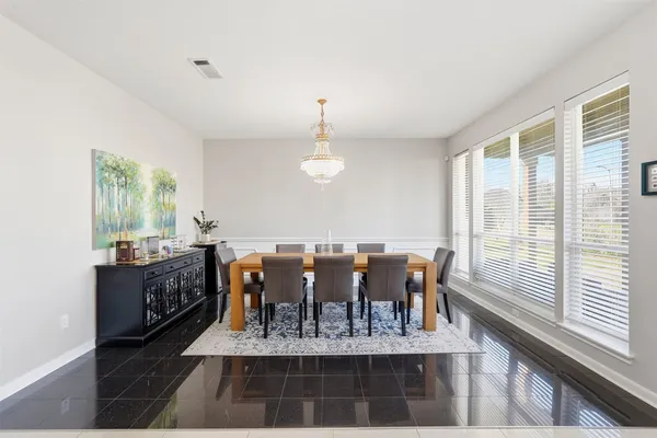 a view of dining room and livingroom with furniture wooden floor a rug and a chandelier
