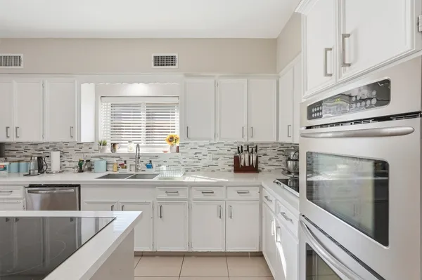 a kitchen with a sink stove and cabinets