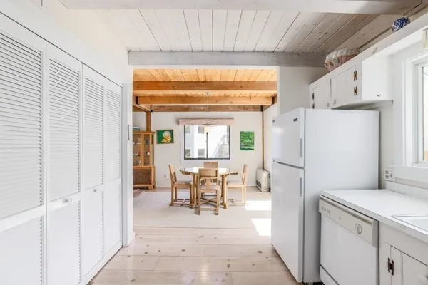 a kitchen with refrigerator a table and chairs