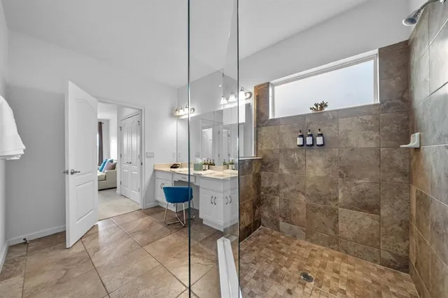 a bedroom with a bed a chandelier and dresser