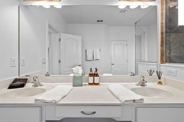 a bedroom with a bed a computer on desk and a dresser