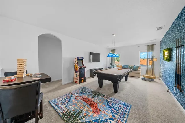 an aerial view of a house with swimming pool and large trees