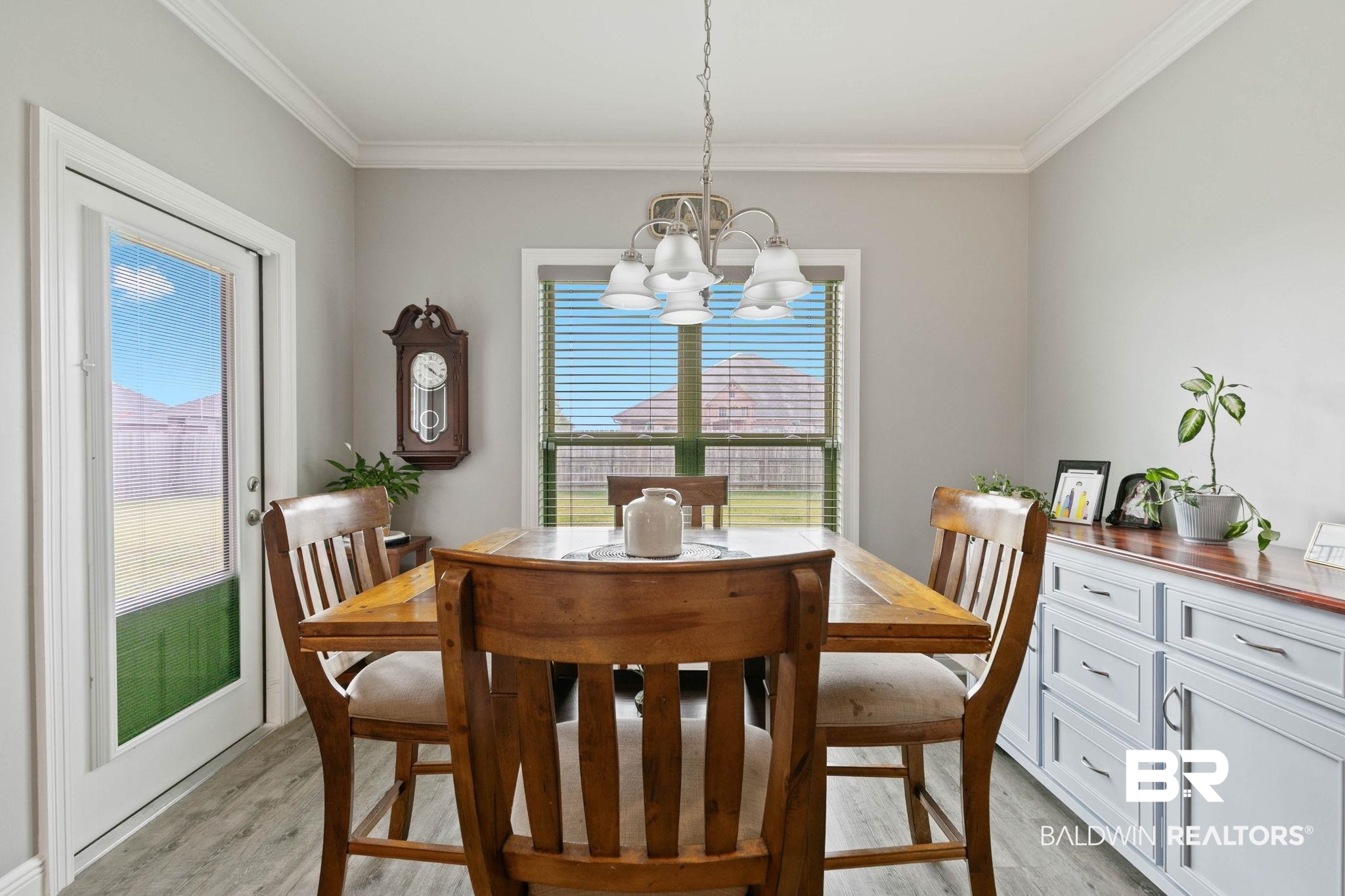 9388 Pembrook Loop Fairhope, AL 36532 - Photo 26 of 53 Dining area featuring light wood-style flooring, ornamental molding, and a chandelier