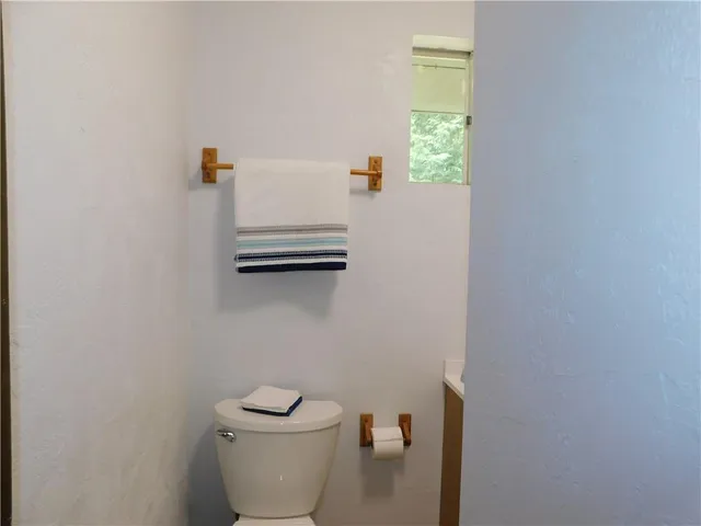 a bathroom with a toilet and a window