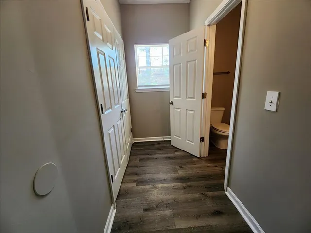 a view of a hallway with wooden floor and staircase