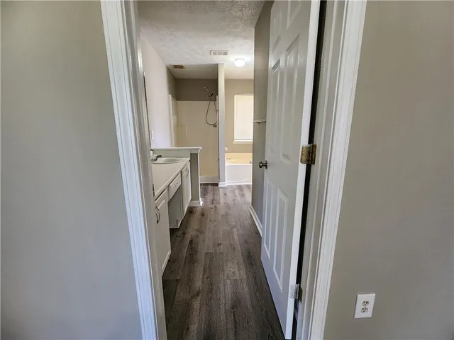 a view of a hallway with wooden floor and staircase