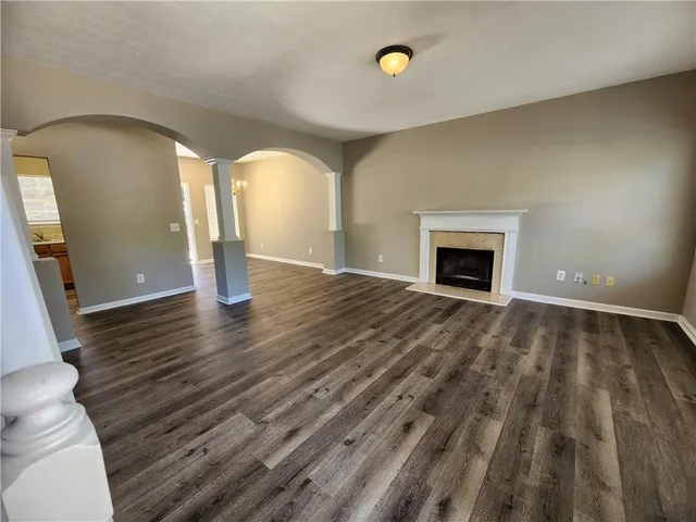 a view of an empty room with glass door and wooden floor