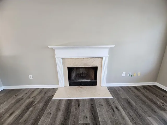 an empty room with wooden floor and fireplace