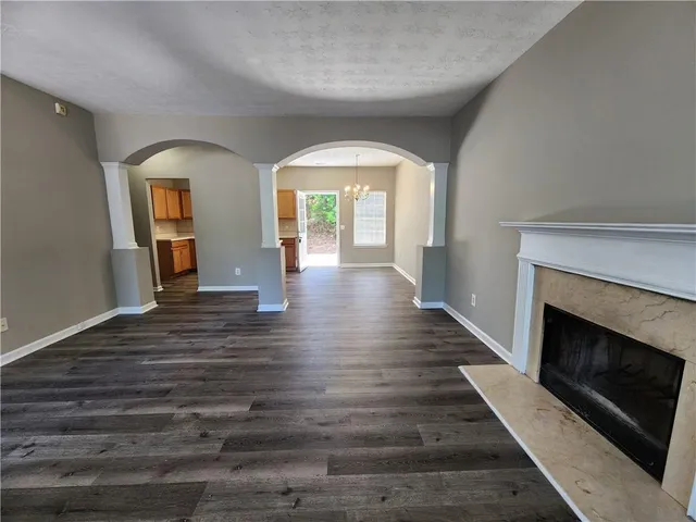 a view of empty room with wooden floor and fireplace