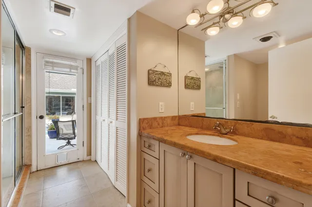 a spacious bathroom with a granite countertop sink and a mirror