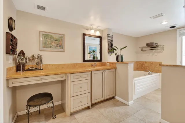 a bathroom with a granite countertop sink vanity and mirror