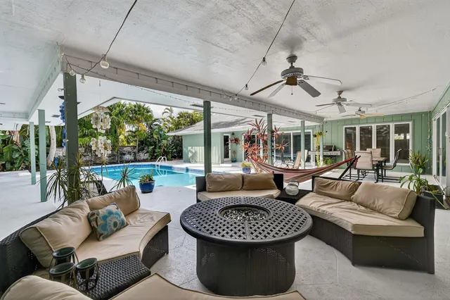 a swimming pool view with a seating space and a garden view