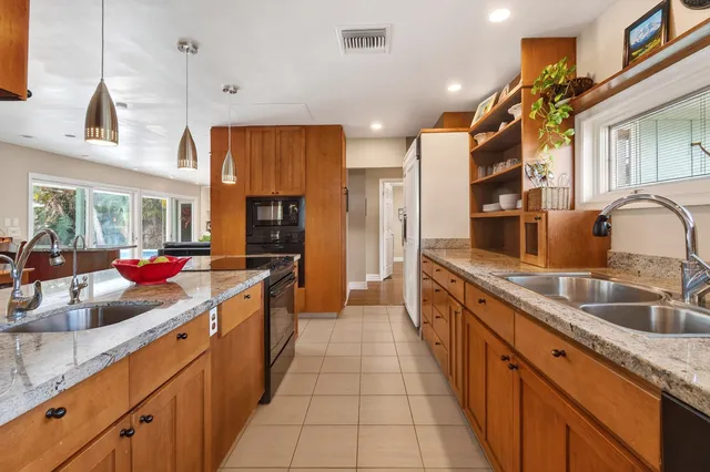 a kitchen with stainless steel appliances granite countertop a sink and a refrigerator