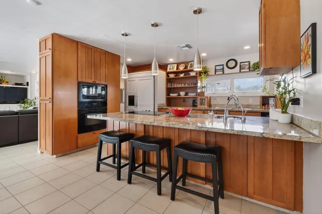 a kitchen with granite countertop a sink a stove and cabinets