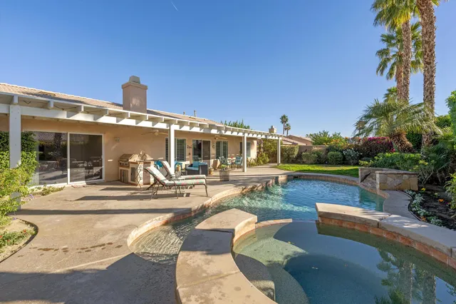 a view of a patio with couches and table and chairs with wooden floor and fence