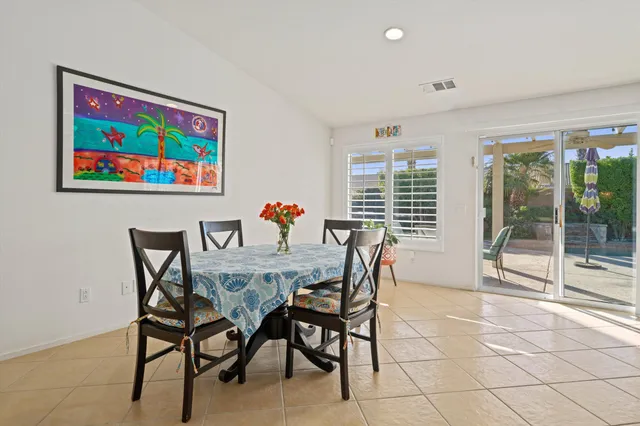 a dining room with furniture and large windows