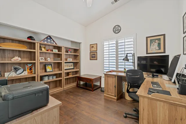 a view of a workspace with furniture and a window