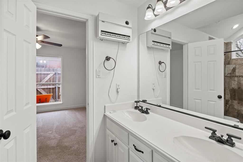 364 Preakness Place Road Van Alstyne, TX 75495 - Photo 29 of 40 a bathroom with a double vanity sink a mirror a shower and a bathtub