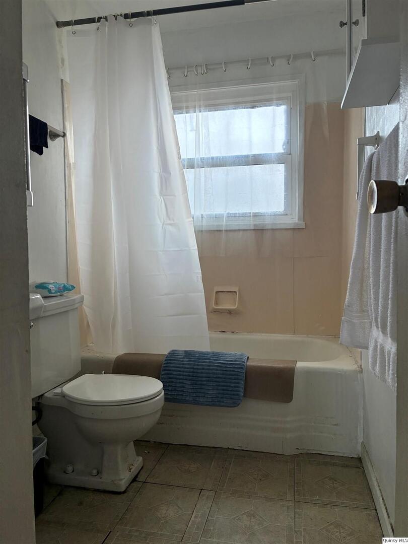 3409 Lawrence Road Quincy, IL 62301 - Photo 6 of 11 a bathroom with a sink a toilet a window and tub