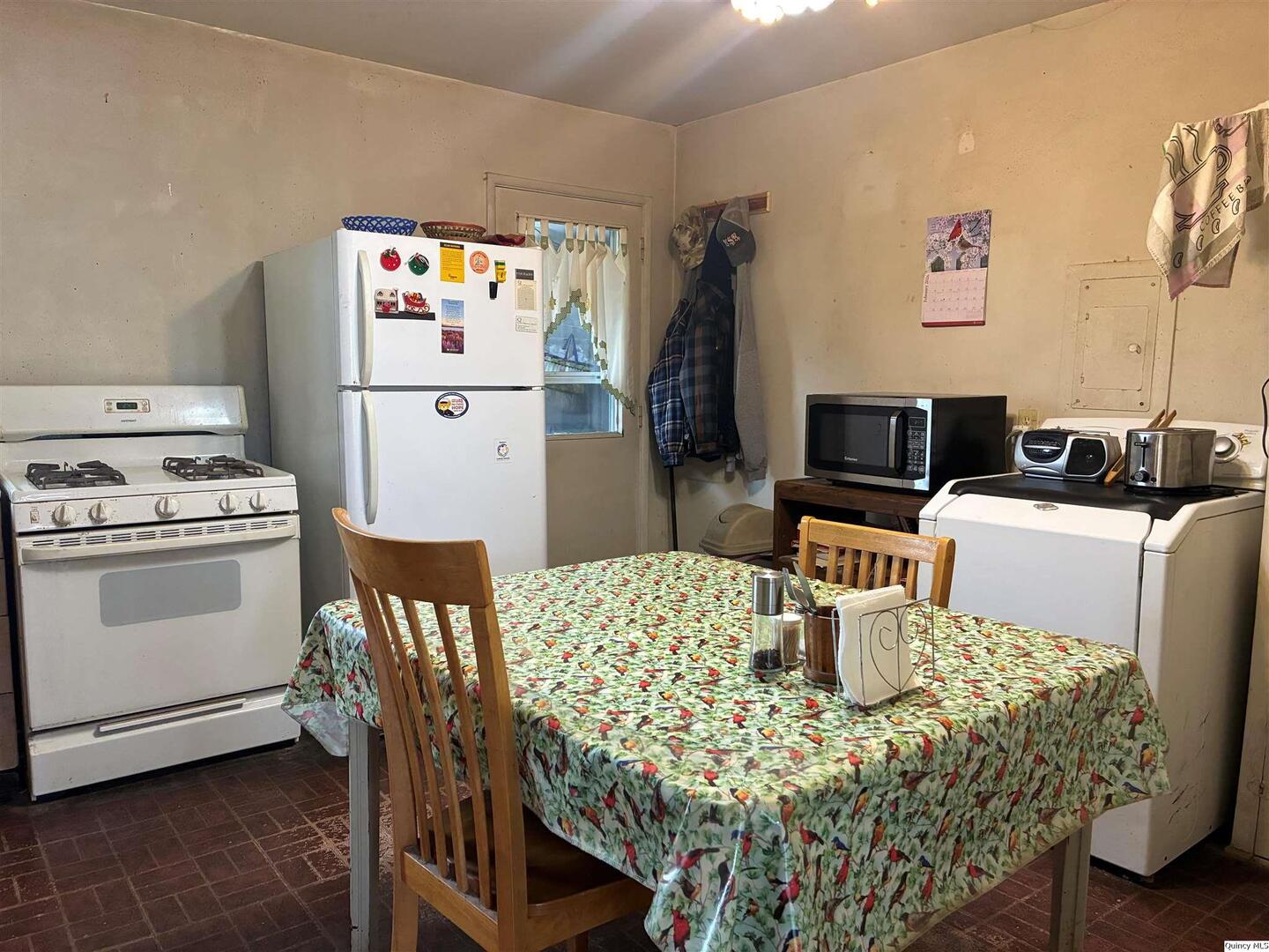 3409 Lawrence Road Quincy, IL 62301 - Photo 7 of 11 a kitchen with a table chairs and a refrigerator