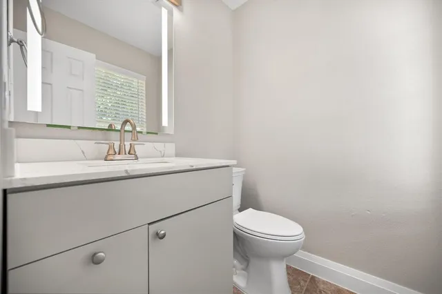 a bathroom with a toilet a sink and mirror