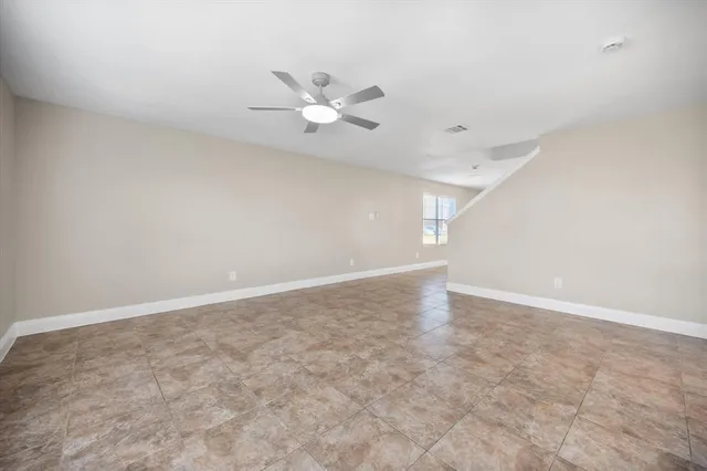 an empty room with an entryway and fan