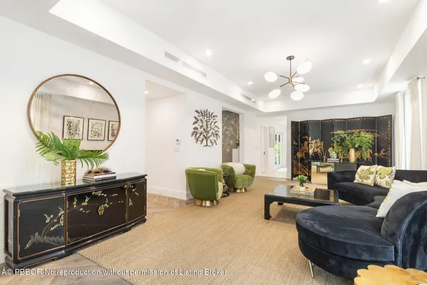 a living room with furniture a chandelier and a wooden floor