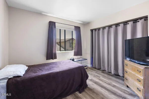 a bedroom with a bed tv and a window