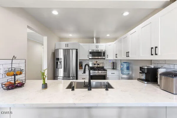 a kitchen with stainless steel appliances kitchen island granite countertop a sink and cabinets