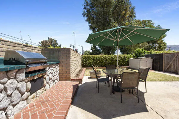 a patio with a table and chairs under an umbrella